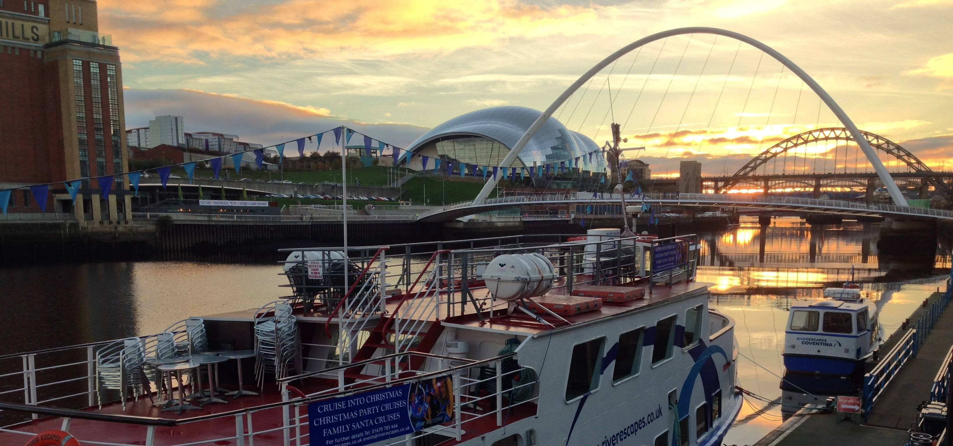 River Escapes Boat in front of the Sage and the Millennium Bridge at sunset - Newcastle Gateshead Qu