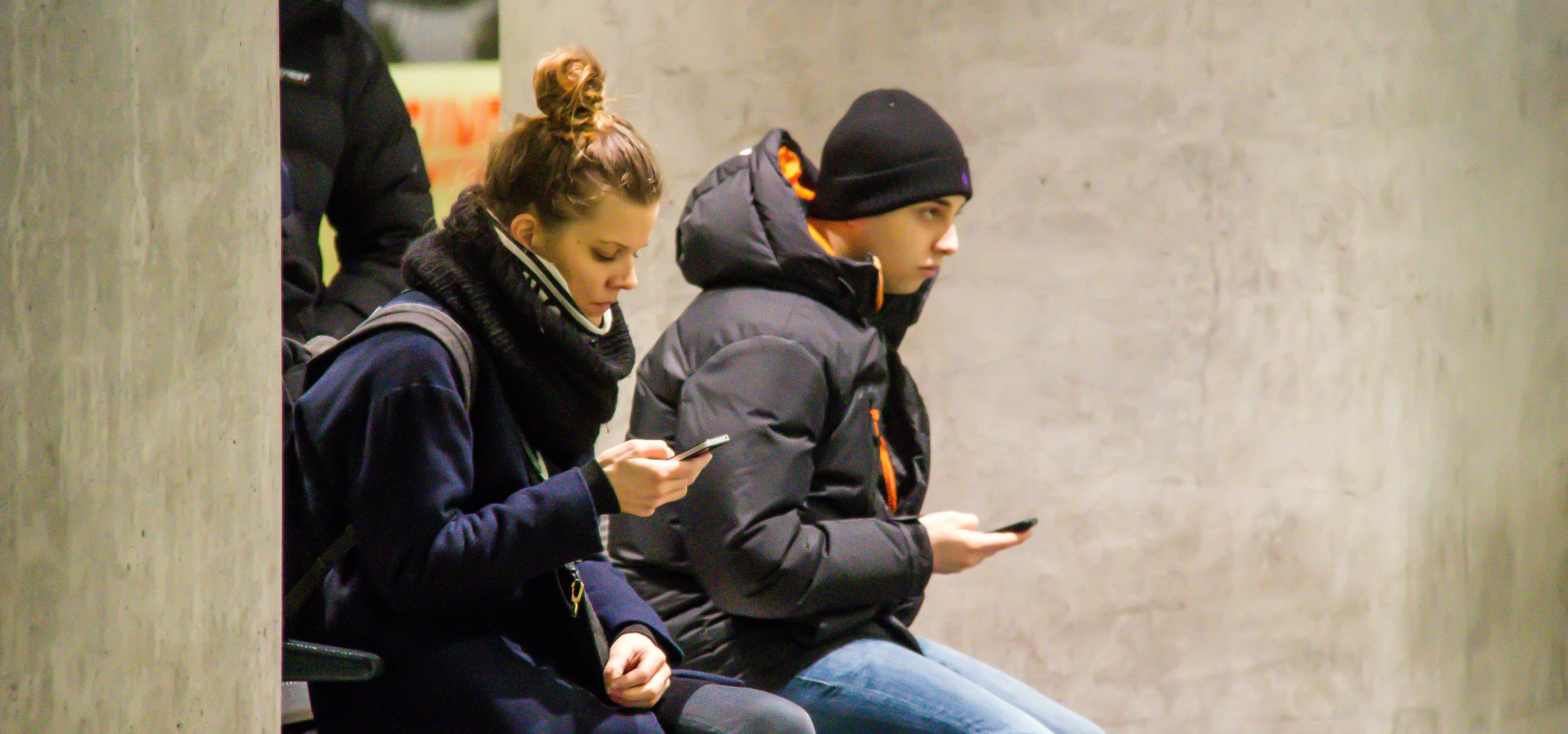 People with phones at the station - texting