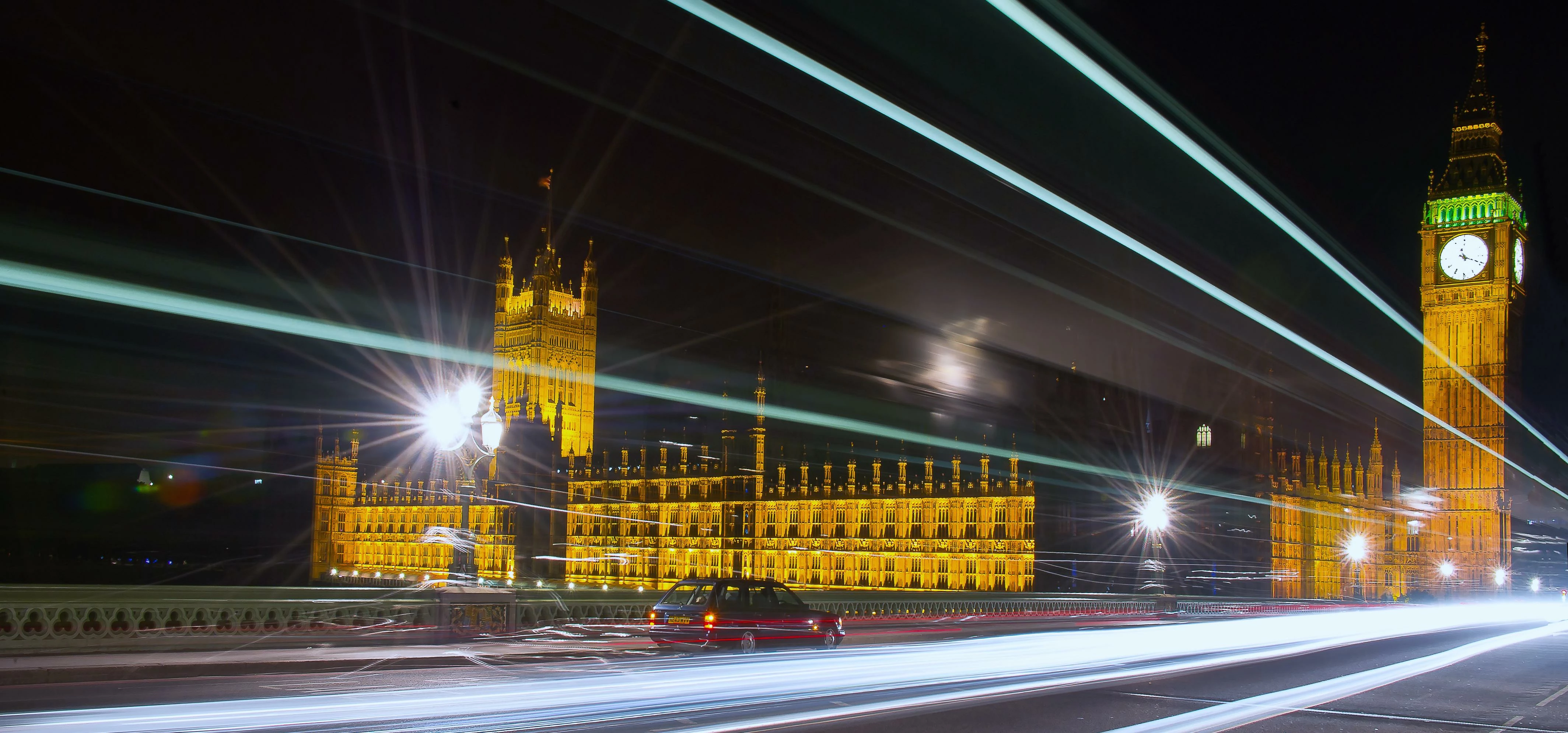 westminster bridge with light trails and showing houses of parliament