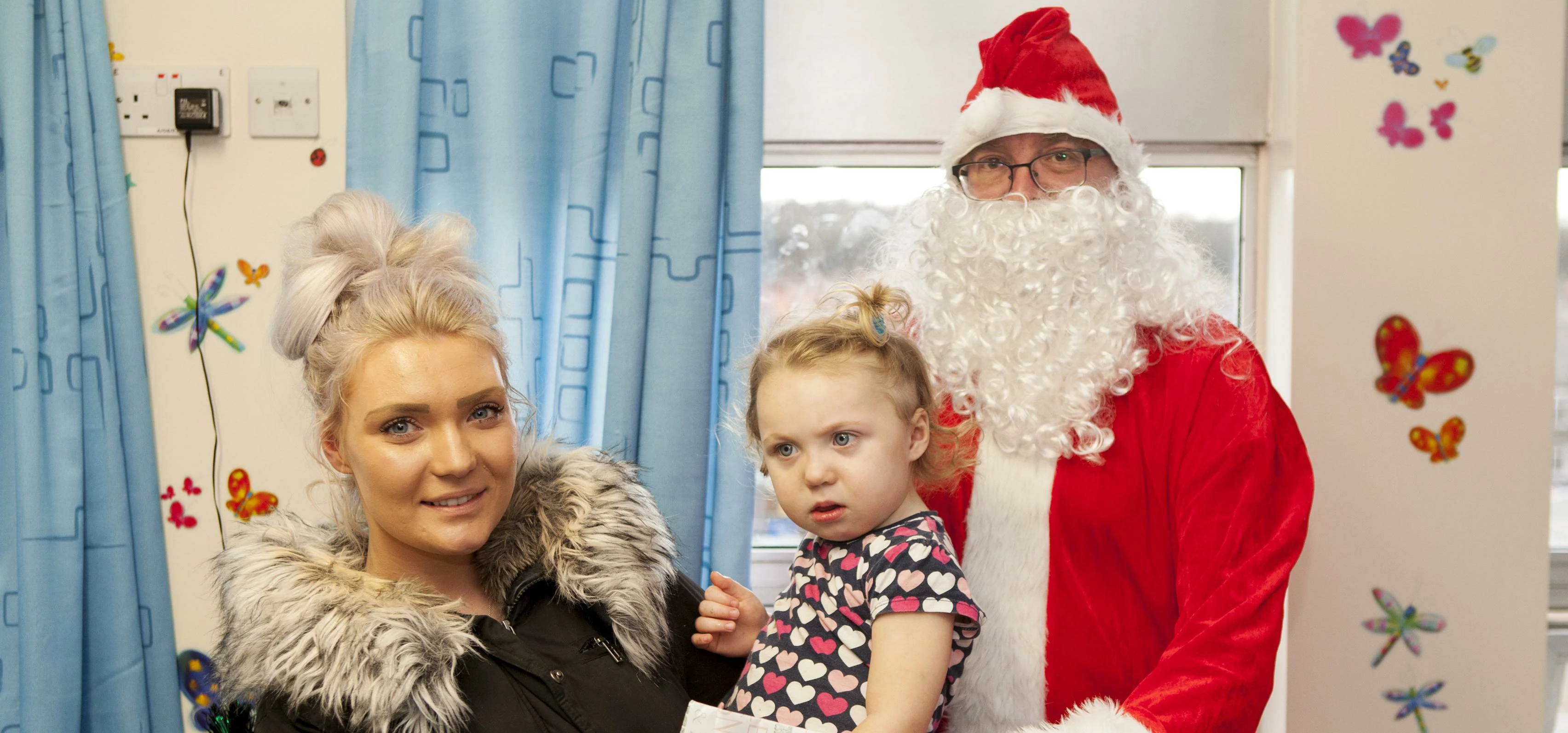 Stephen Haram (Santa) giving a present to 2 year old to Cienna Emmerson with Mother Chloe Bradford f