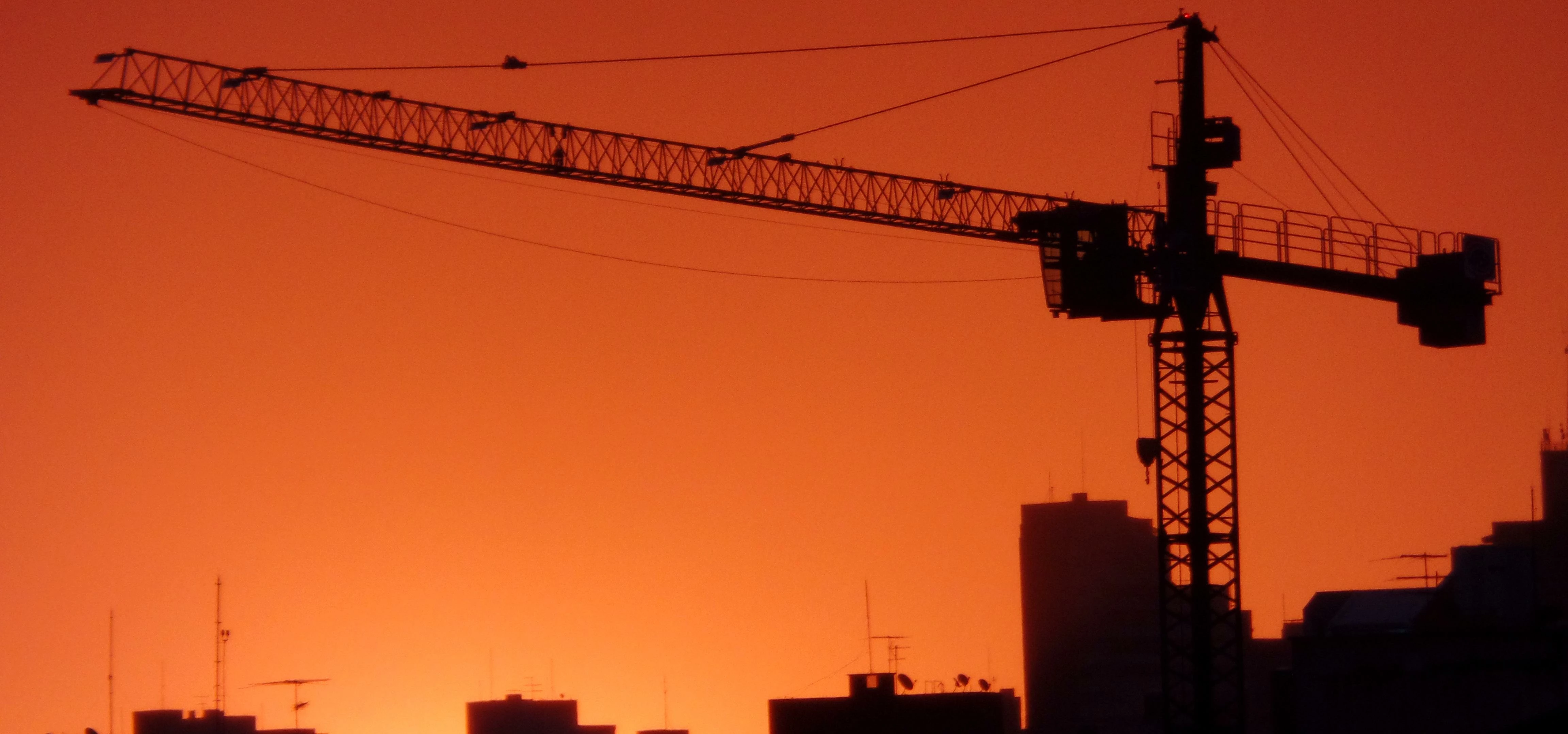 Prédios e guindaste no pôr-do-sol em Curitiba, PR