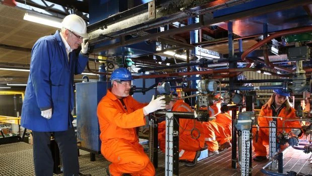 TTE instructor Dave Stevenson (left) oversees AMEC trainee Neil Petrie (crouching second left) while