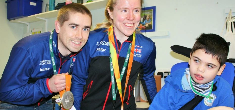 Neil and Lora Fachie show some of their many medals to Seashell Trust student Cayman Norton