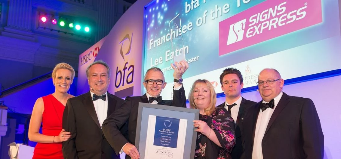 Lee Eaton, franchisee of Signs Express in Manchester, collects his award from judges and Steph McGov