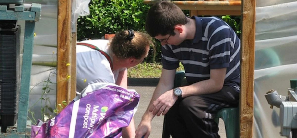 Jonathan supervised by a member of the Green Team whilst attending to allotment and greenhouse proje