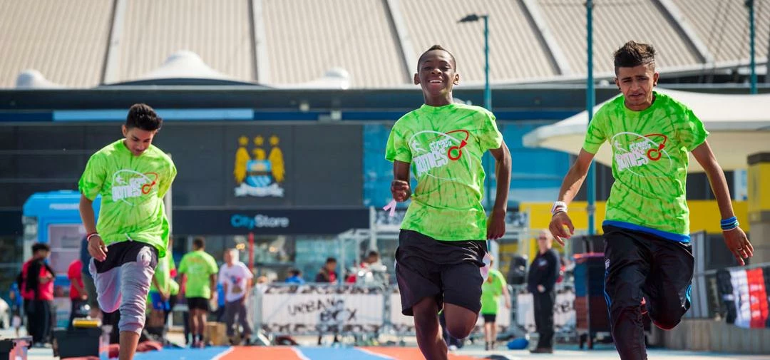 Youngsters racing on the pop up running track at Manchester's SportCity