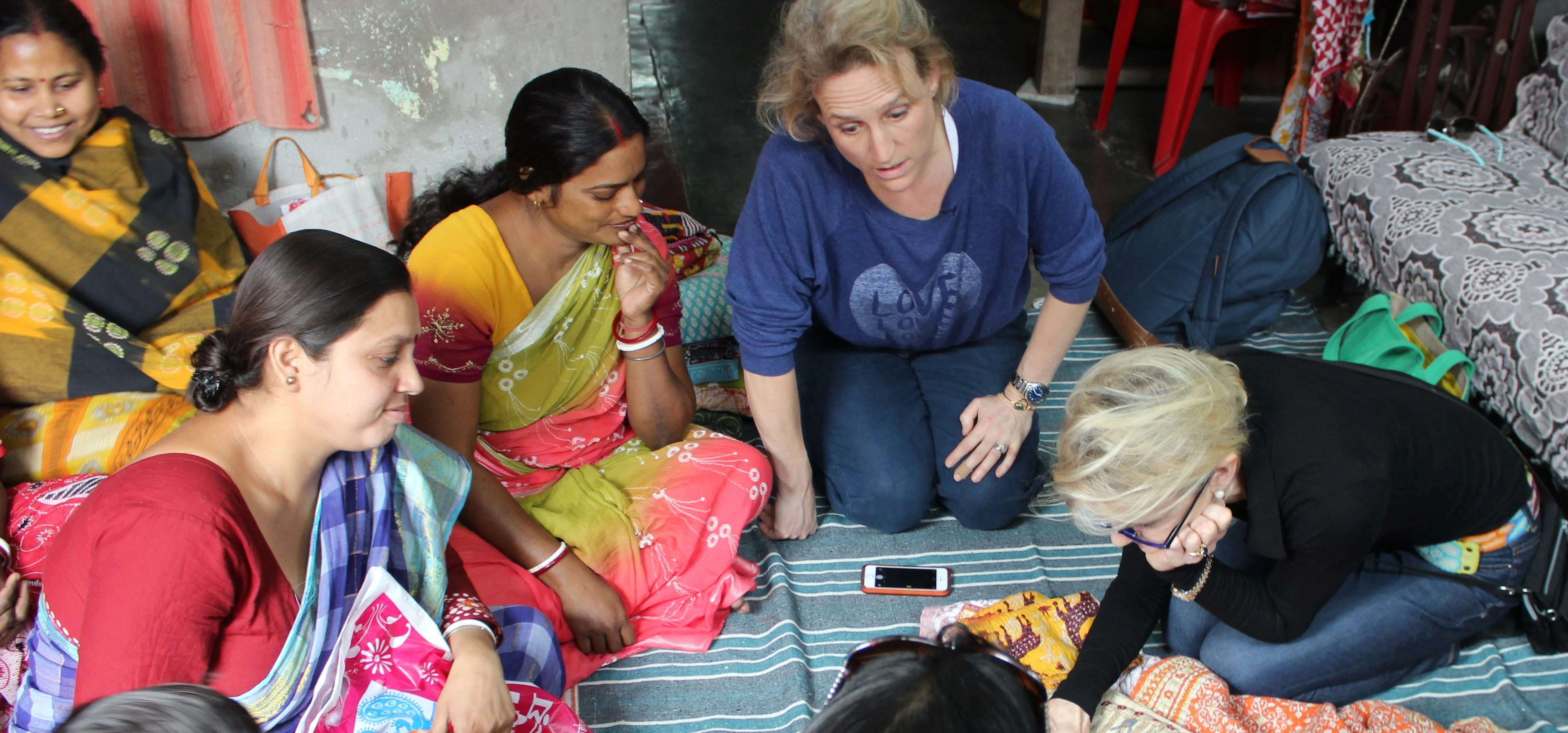 Claire McApline and Eliza Browne-Swinburne discussing textiles with the women from India