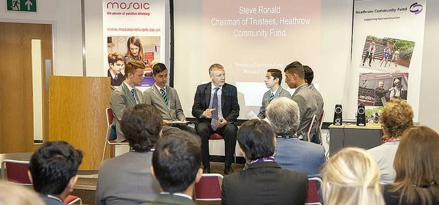 Steve Ronald, Chairman of Trustees for the Heathrow Community Fund, talks with students at the Mosai