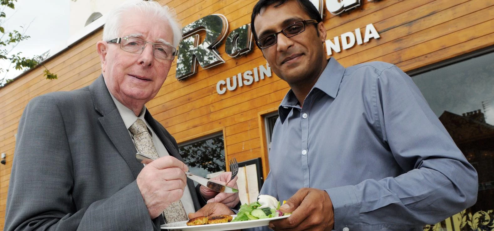 Radhuni owner Kowsar Choudhury shows some of the food to Councillor Kerr