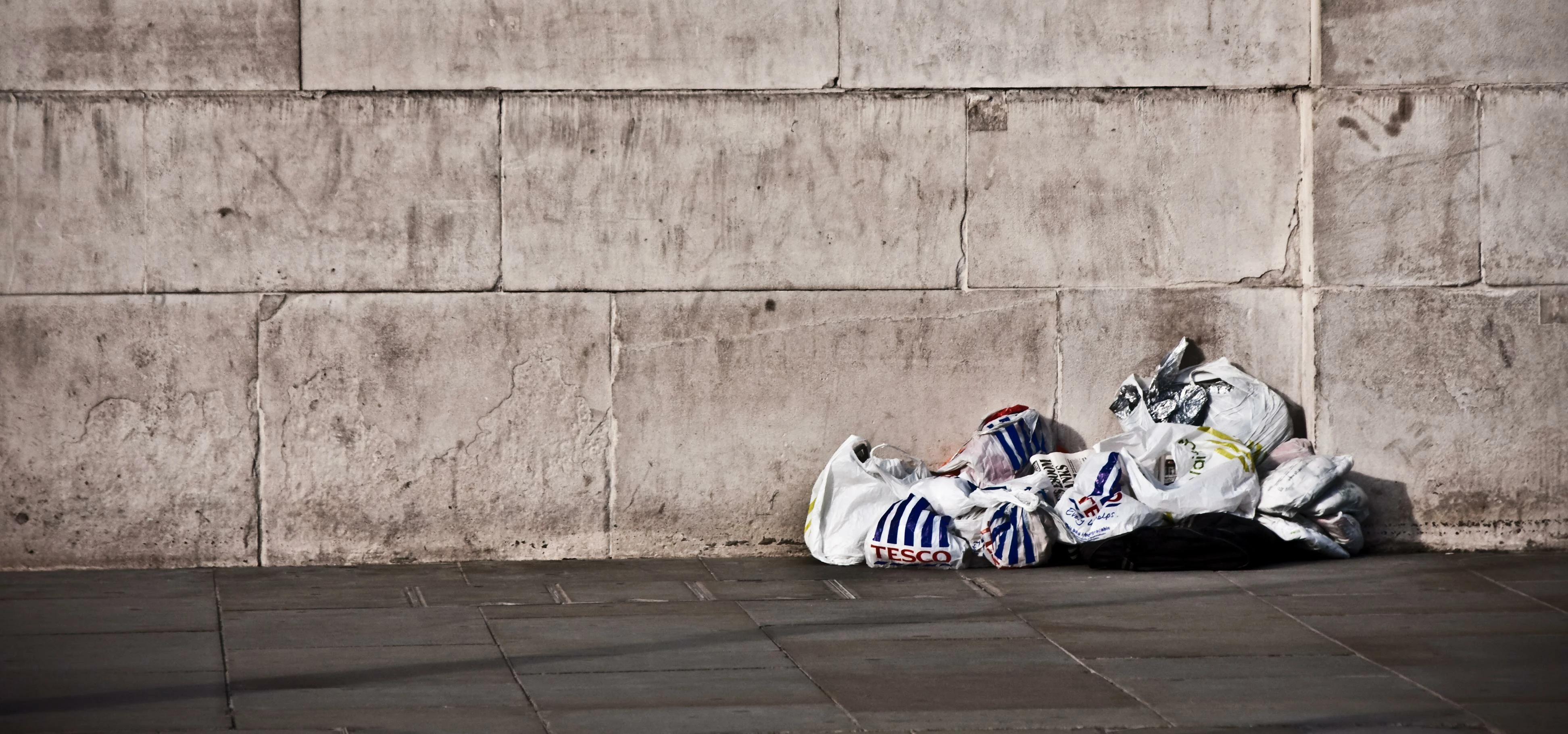 Under Carrier Bags By A Wall