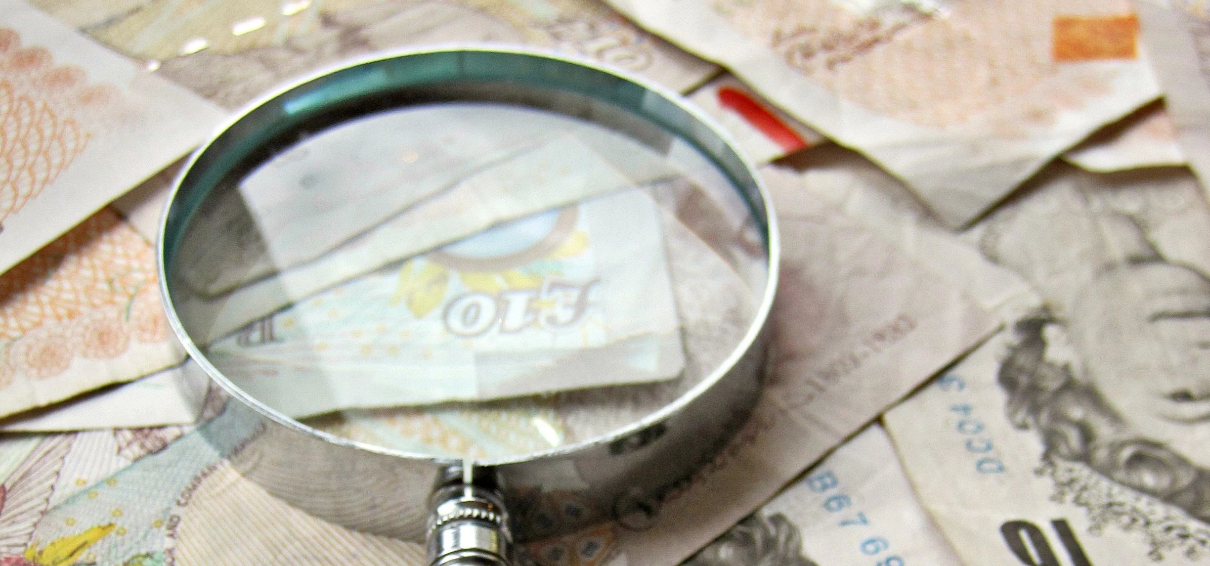 UK Pounds and magnifying glass