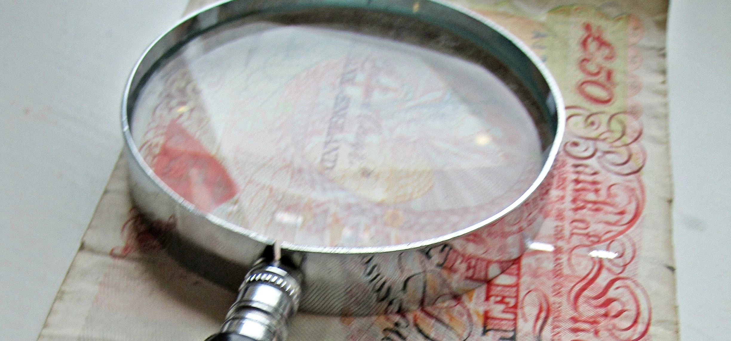 Magnify glass and 50 pound note