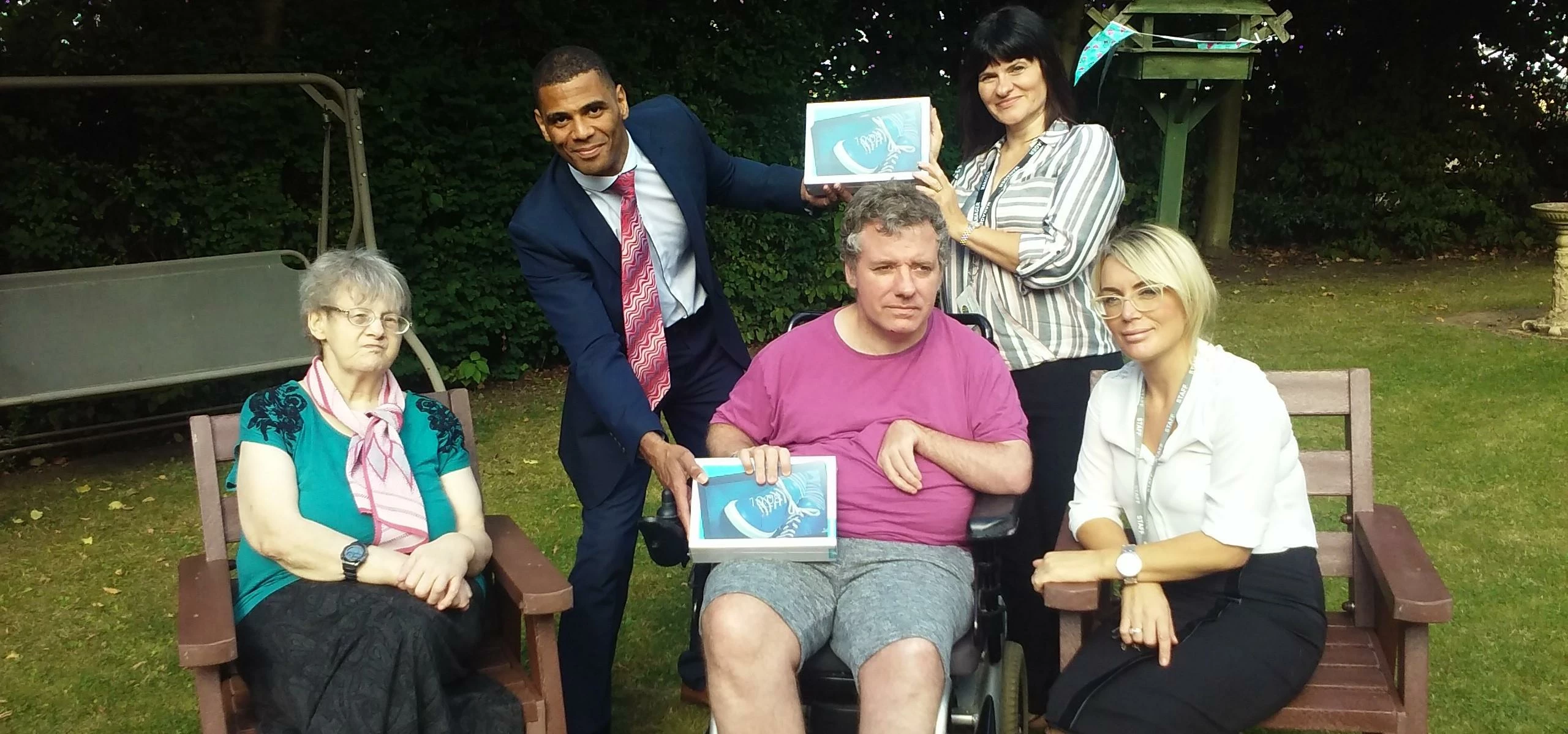 Residents and staff at prospect house receiving a donation of tablet computers