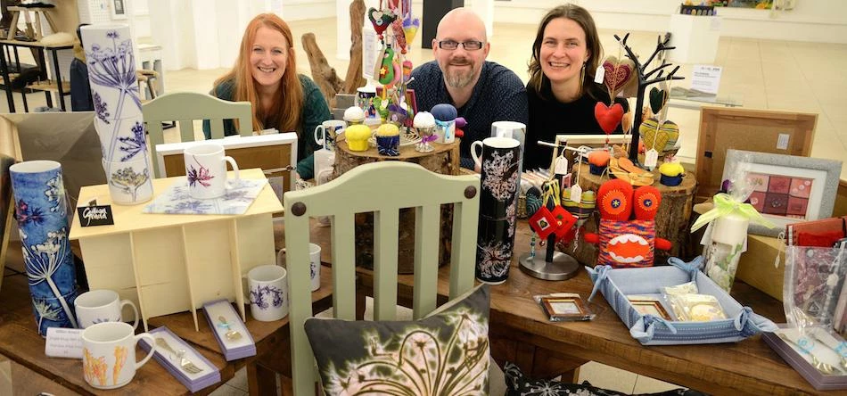 Gillian Arnold, husband Tim and Pod manager Kate Gorman with a selection of products on offer in Pod
