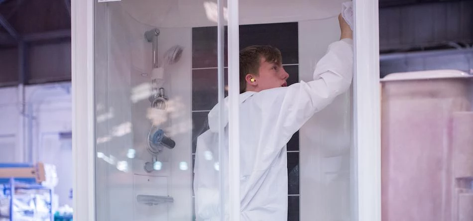 Lamplas employee quality checking a shower pod before dispatch