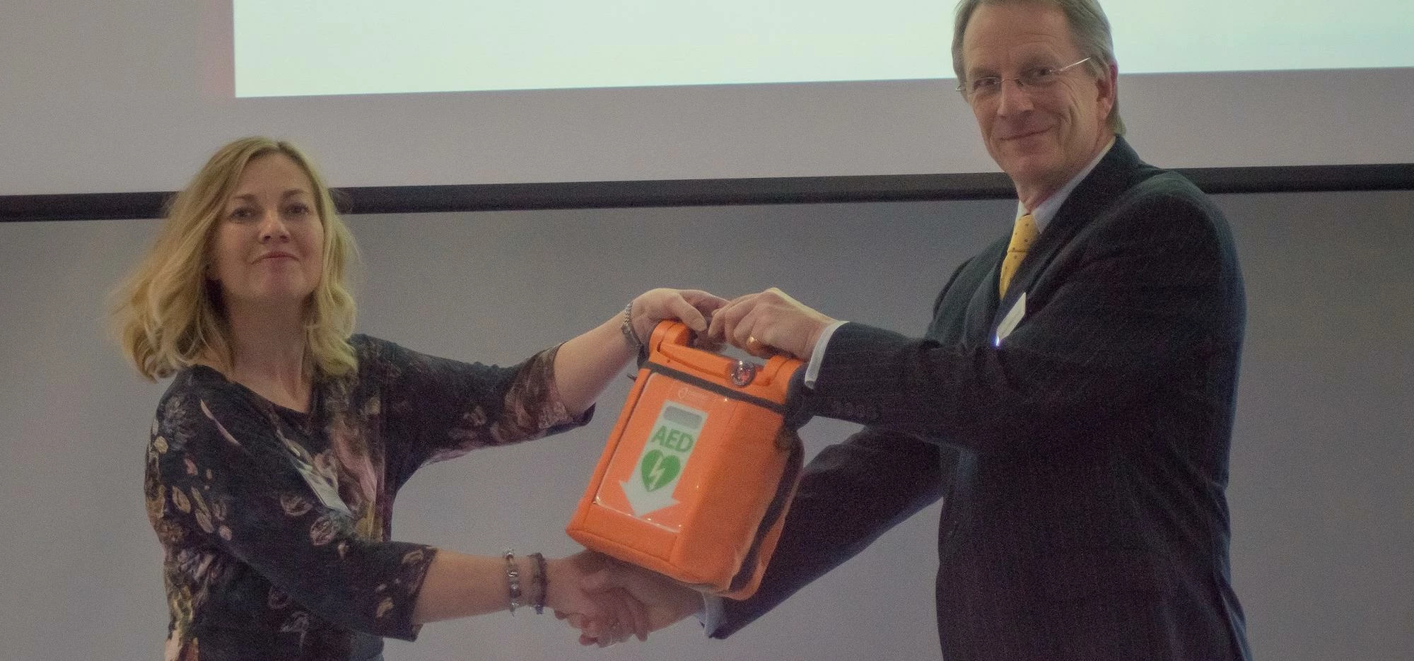 Carole Conroy, Senior Lecturer in Health and Safety, University of Salford receives the defib from C