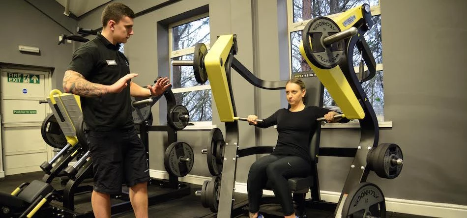A team member at Bannatyne Health Club helps a member get to grips with the new equipment