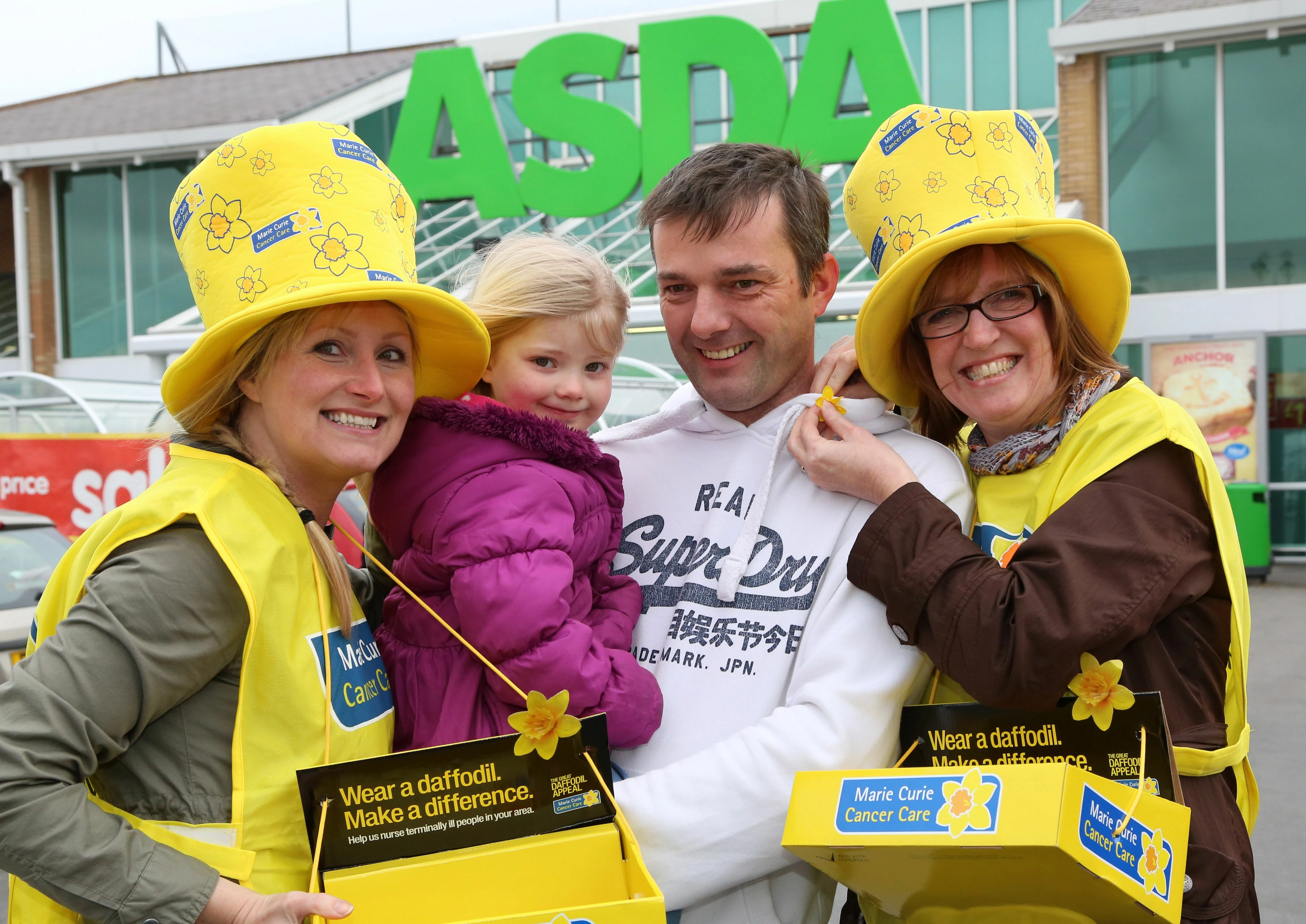 Paul Appleby and daughter Lucy (3) purchase a Marie Curie daffodil from EDF Energy workers Karen Saw