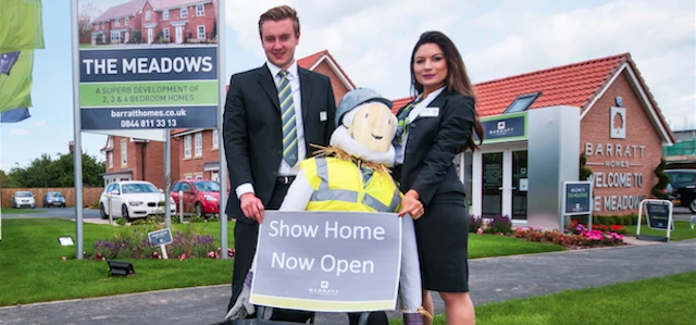 Sales Advisers at The Meadows development with scarecrow