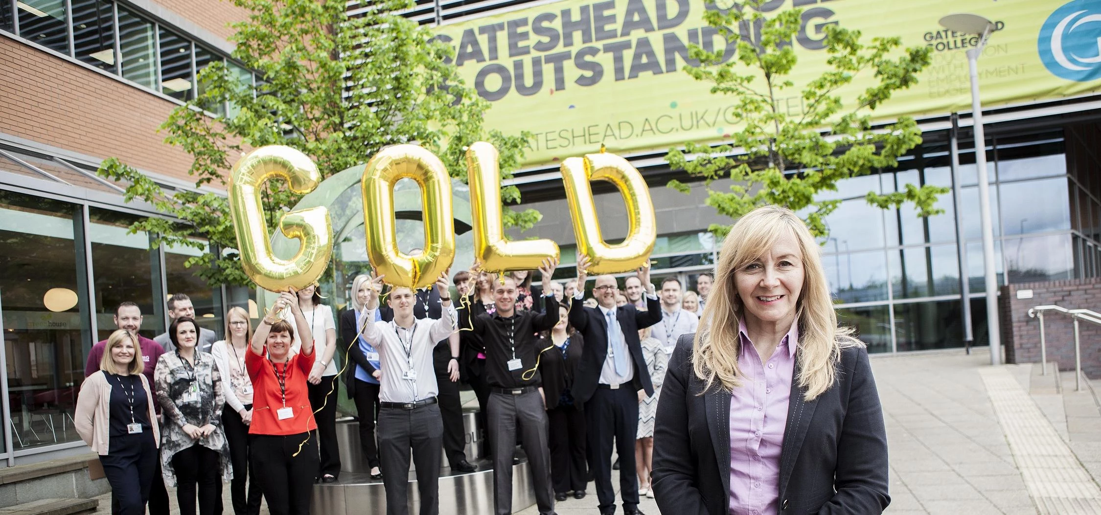 Gateshead College principal and chief executive Judith Doyle with employees celebrating the IIP Gold