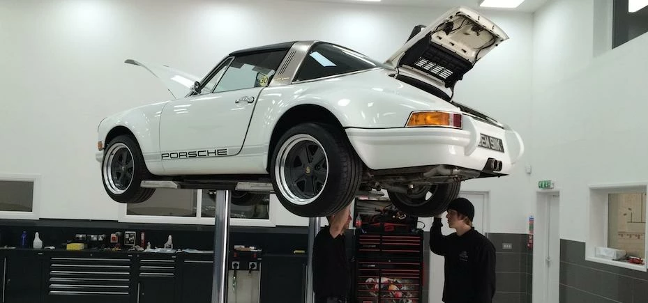 Members of John Holland’s aftersales department look over a Porsche 911 in the company’s new in-hous