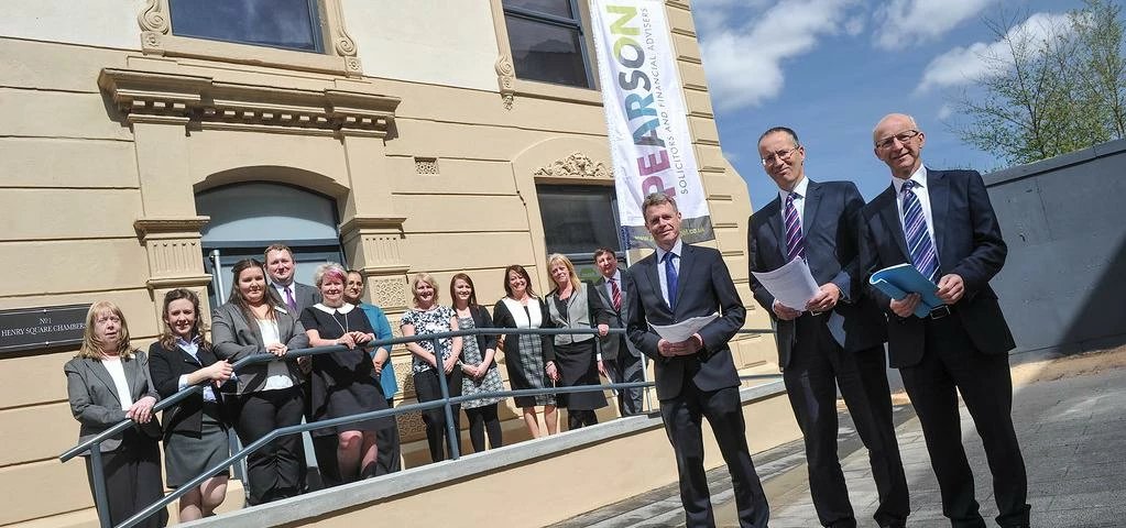 Pearson staff outside the new offices in Ashton