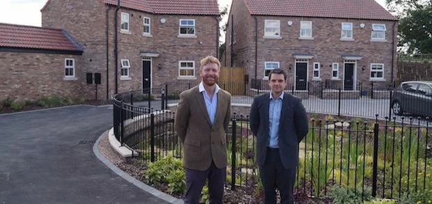 outside their recently-completed housing scheme at York Gardens, Dunnington, York, are Alcuin Homes 