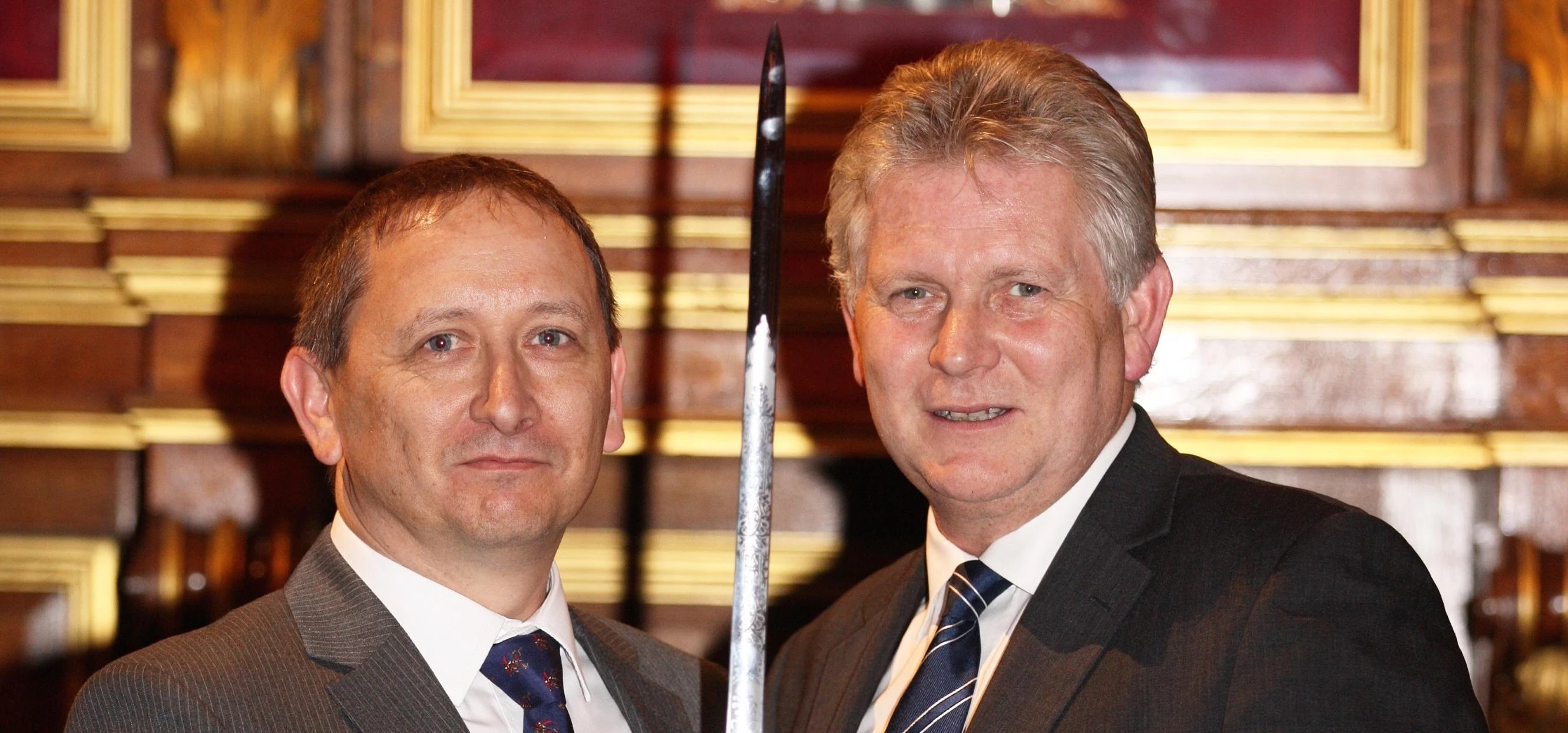 Metromail's Neil Buckett being presented the sword by Mike Robinson, chief executive of the British 