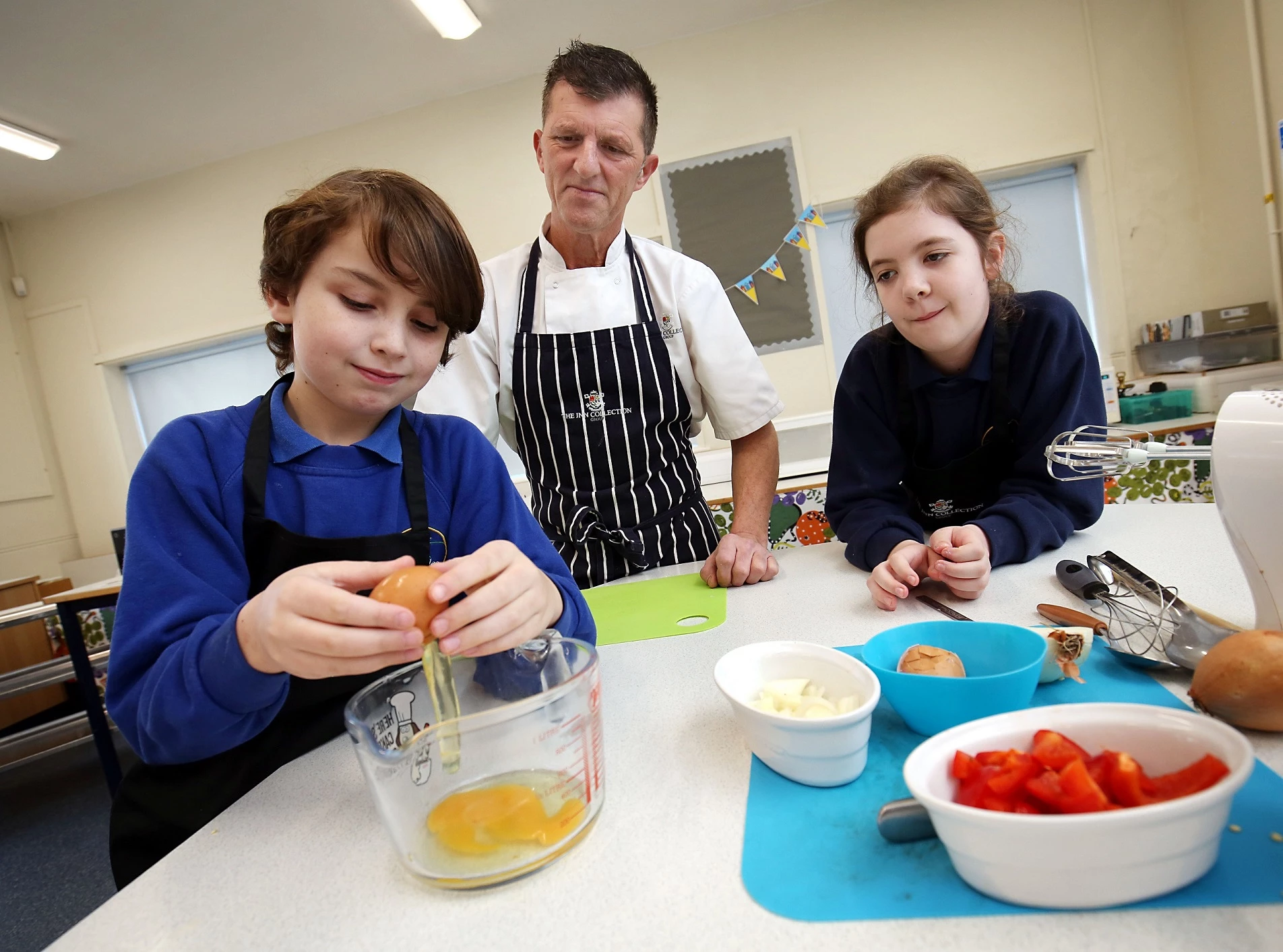 Leighton and Scarlett help Richie Moore, Group Development Chef with the Inn Collection Group, make an omelette