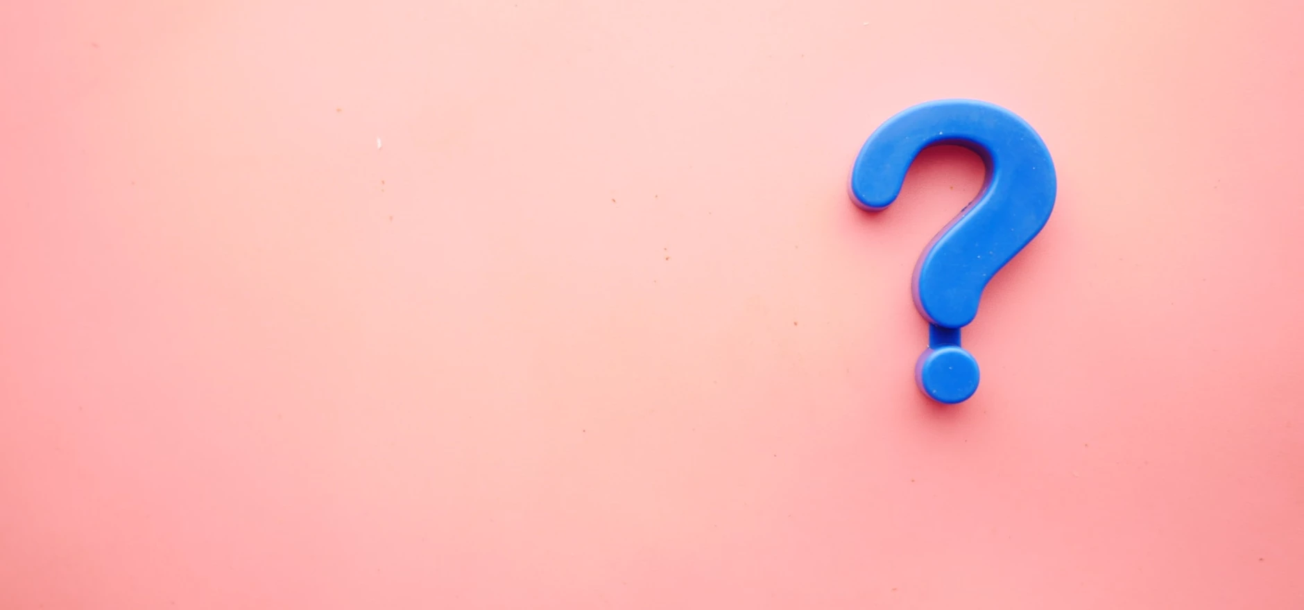 Blue plastic question mark on a pink background