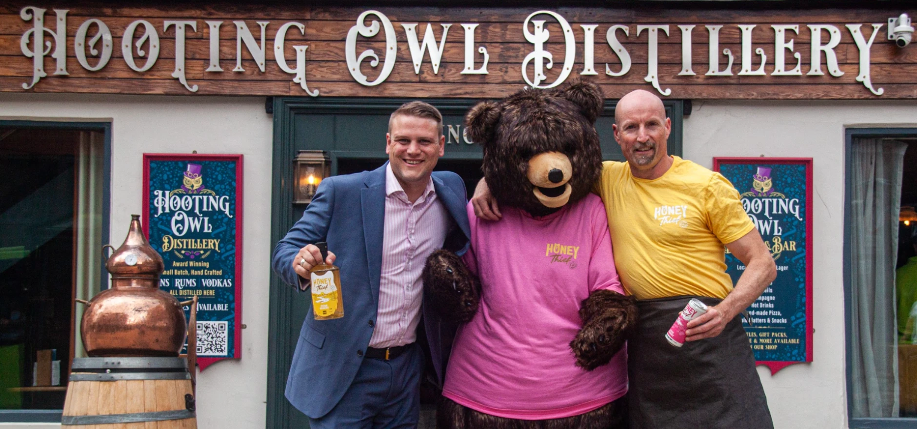 Peter Taylor, left, founder of Honey Thief, and mixologist Jamie Stephenson, right, with Honey Thief mascot Arthur the Bear