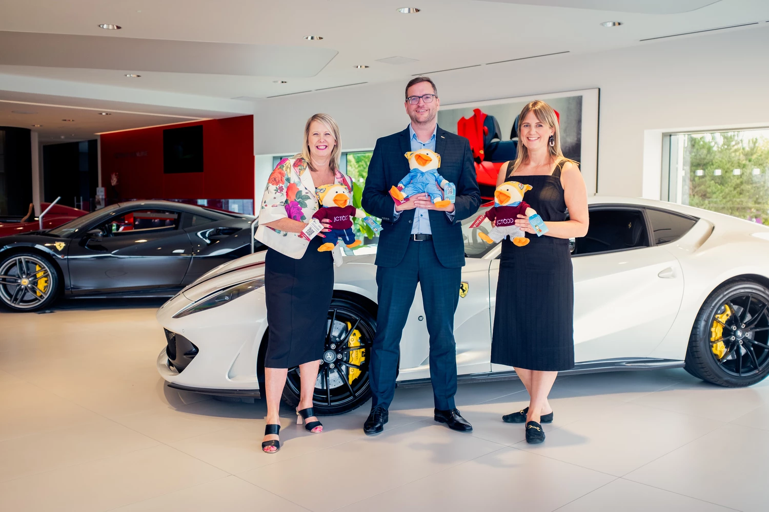 (L to R): Elaine Dunning, Give a Duck Fundraising Manager; Andy Bateman of JCT600; and Eve Corry, Give a Duck Development Manager, at JCT600’s Ferrari dealership in Leeds