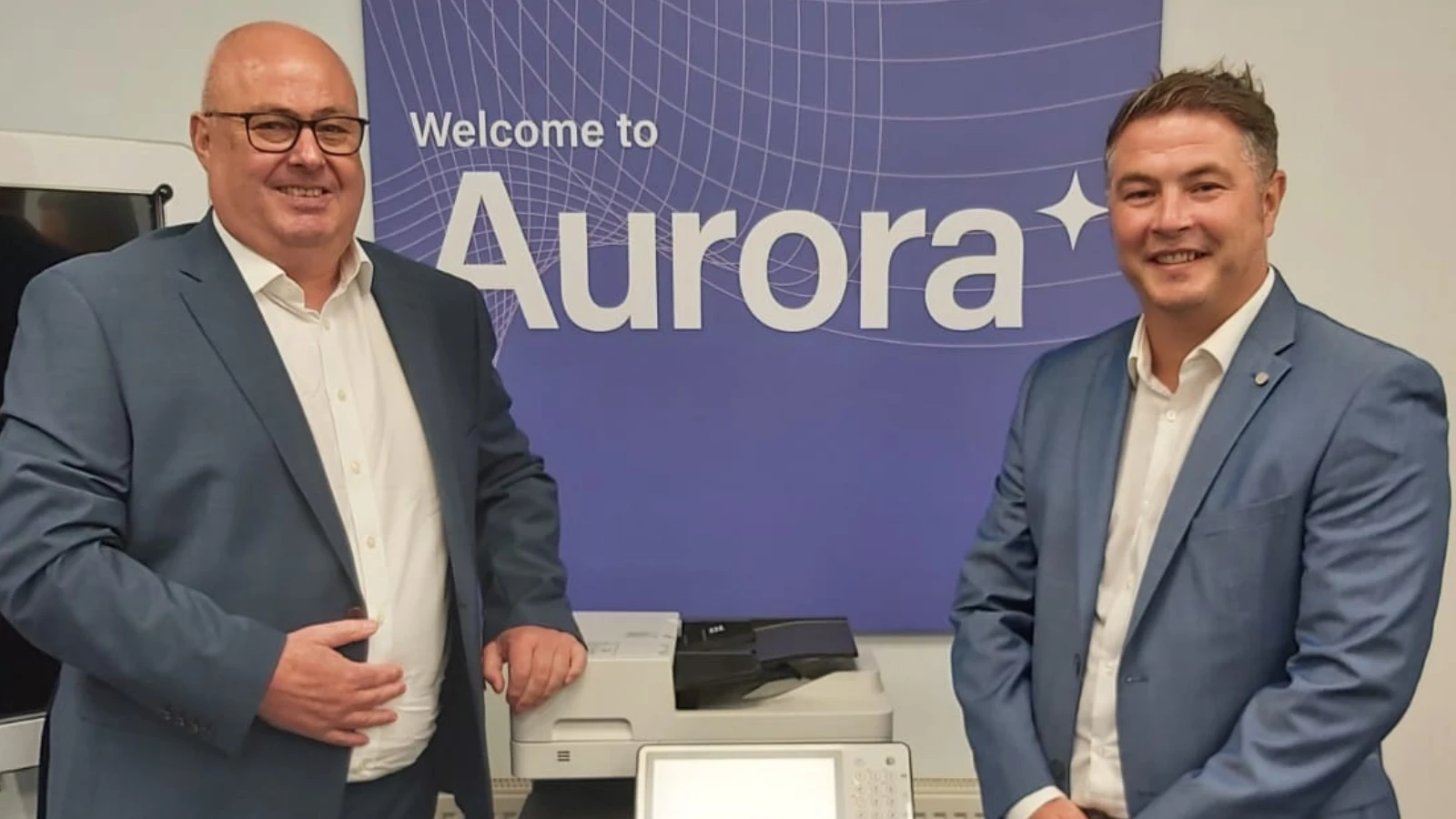  Aurora Managed Print Services team in front of a printer