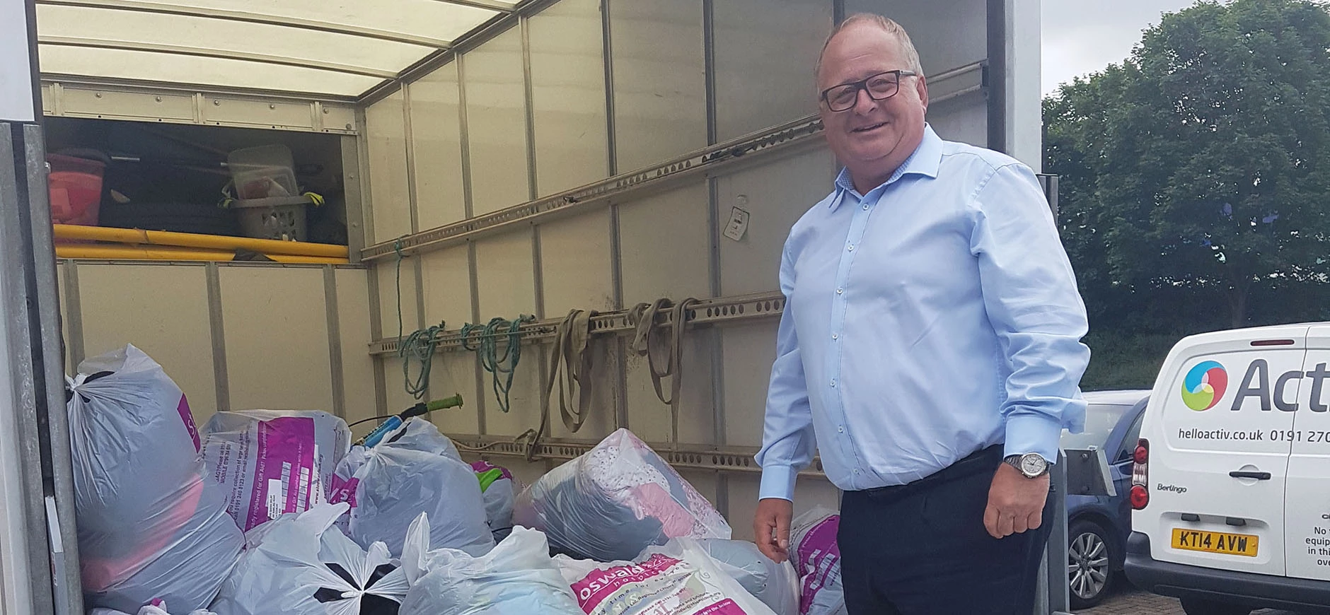 Activ's MD Ian helping put the donation bags onto St Oswald's Collection Van