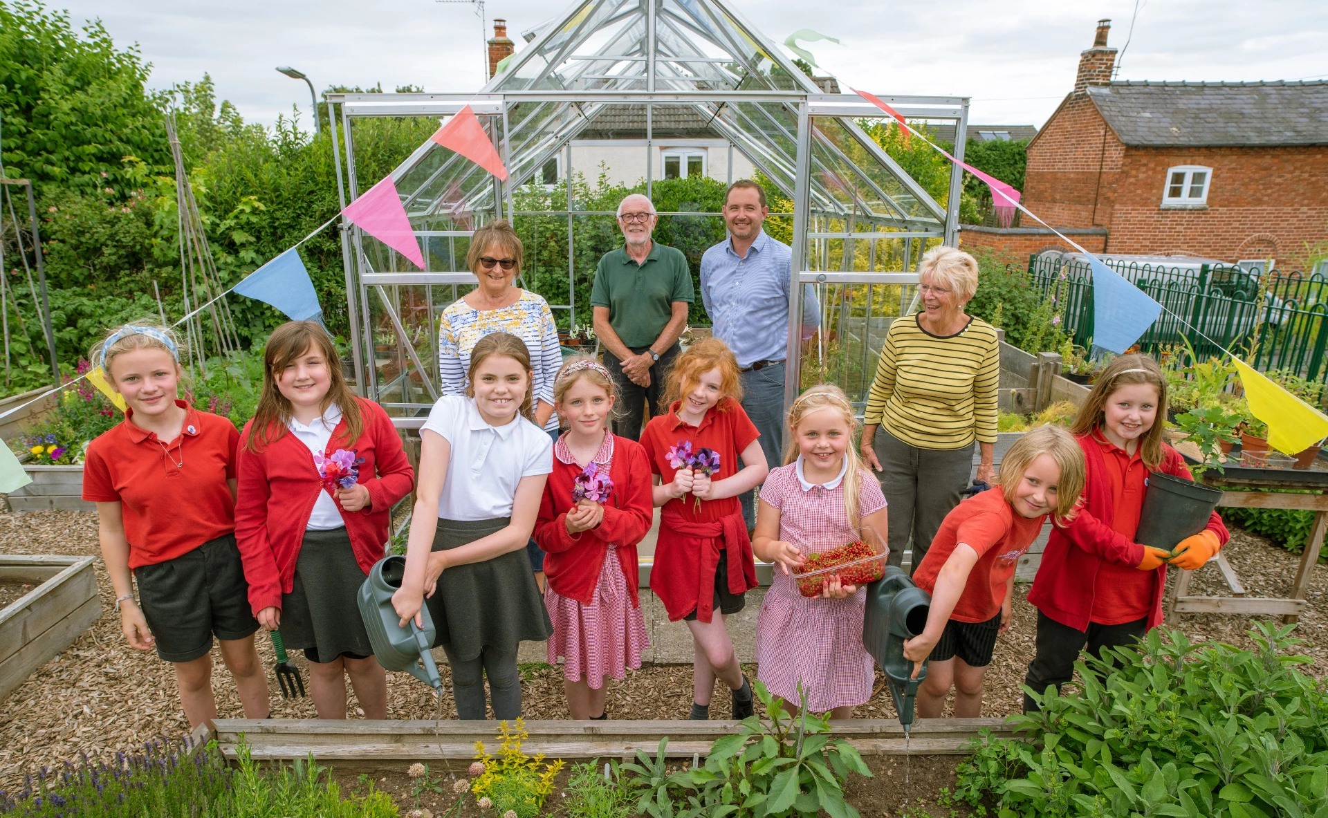 The Wigley Group Chief Executive Officer James Davies (back right) with members of Stockton Community Garden Project and children, outside the new greenhouse