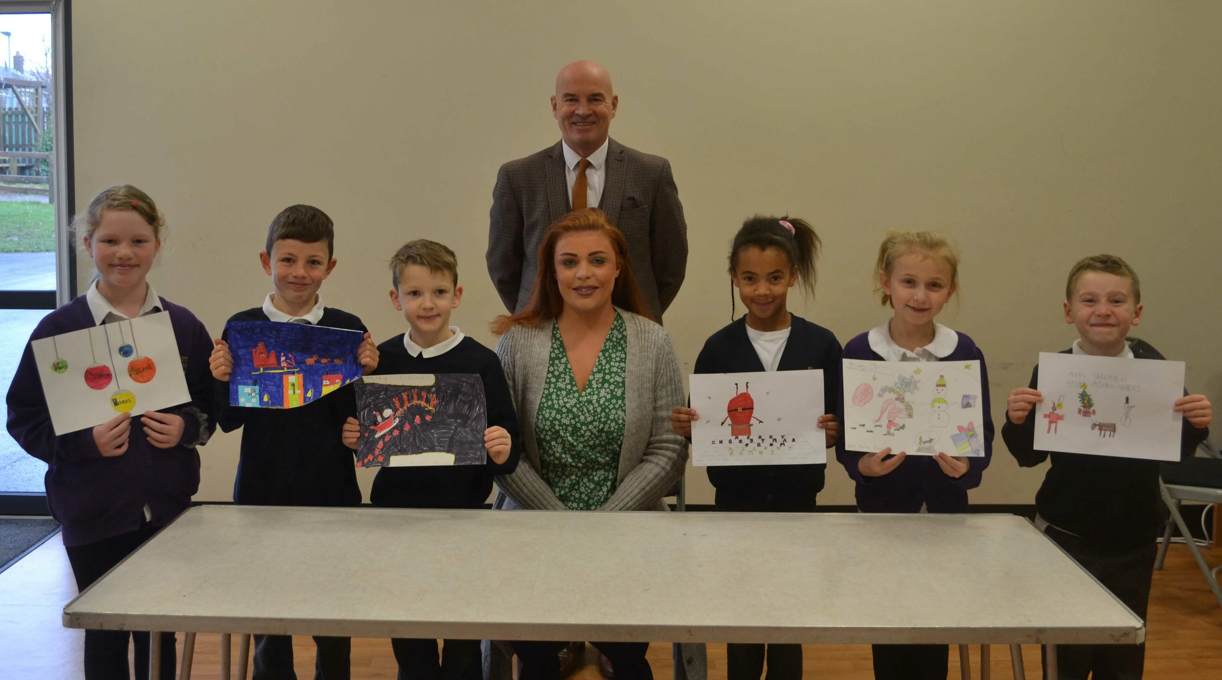 : L t r, Winning students holding the drawings to be used as signage at Wayside Point, Olivia, Will, Miles, Robyn Murray of Ascent Homes, Kevin Vardy Headteacher at Ellington Primary School, Sophie and Henry.