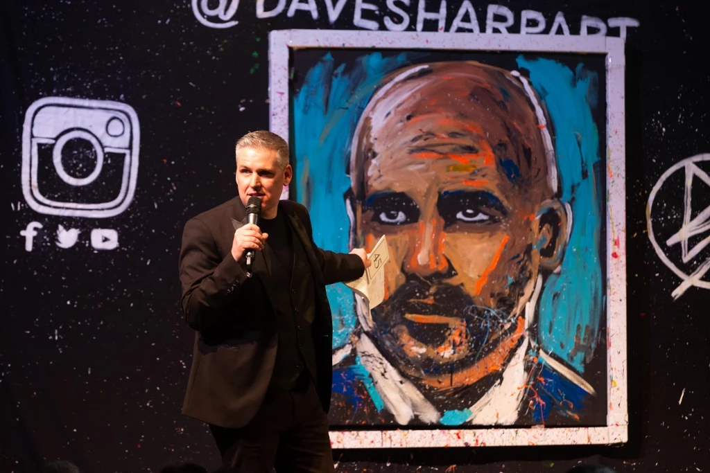 Event compere Trevor Jordan with Dave Sharp’s painting of Pep Guardiola