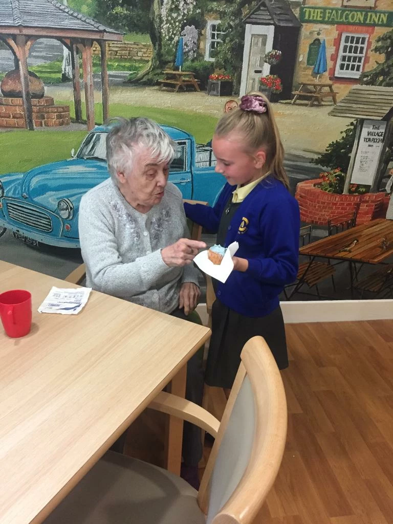 Haslington Lodge care home resident and Craylands Primary School student sharing a cup cake during care home open day on the 28th of June 2019  