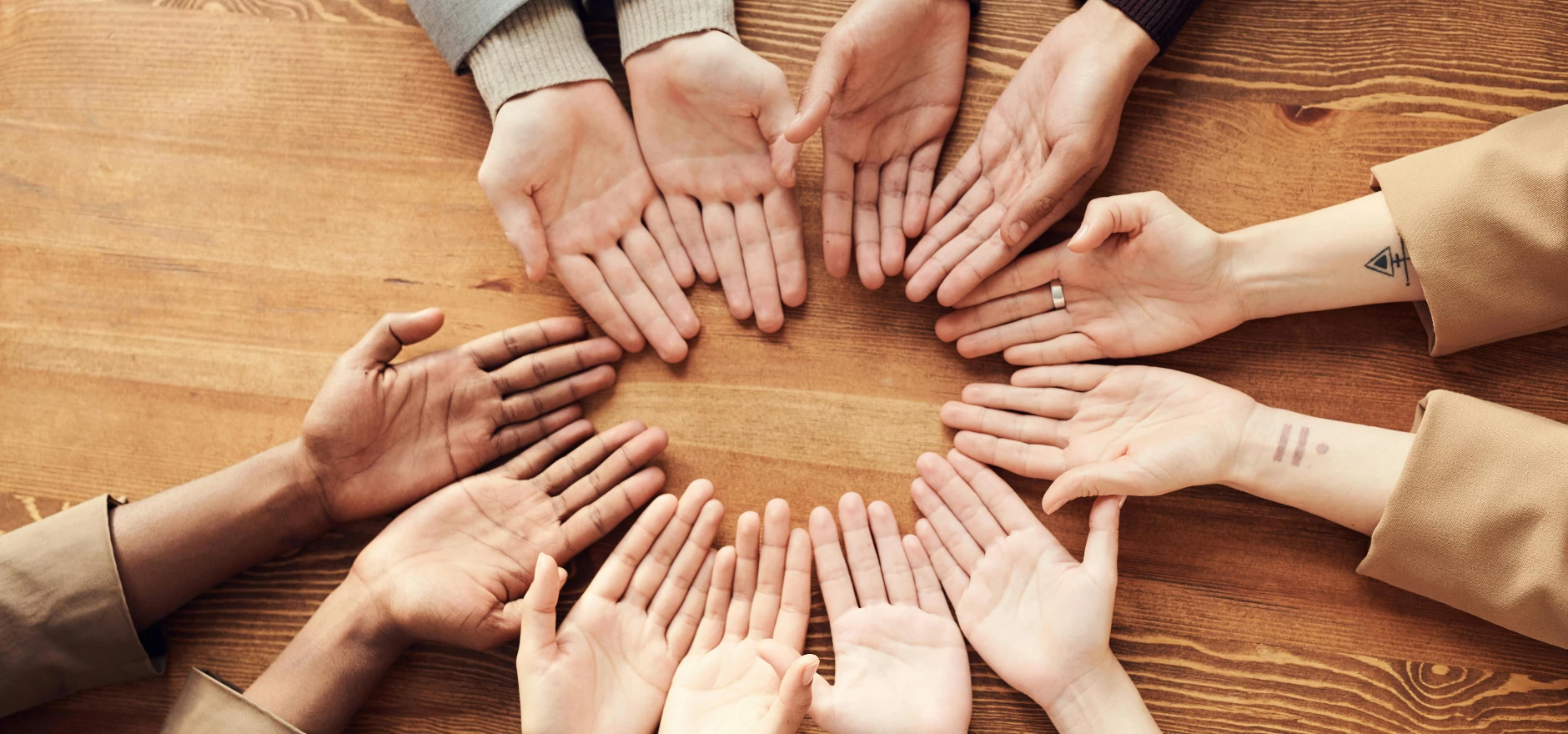 Photo Of People's Hand On Top Of Wooden Table