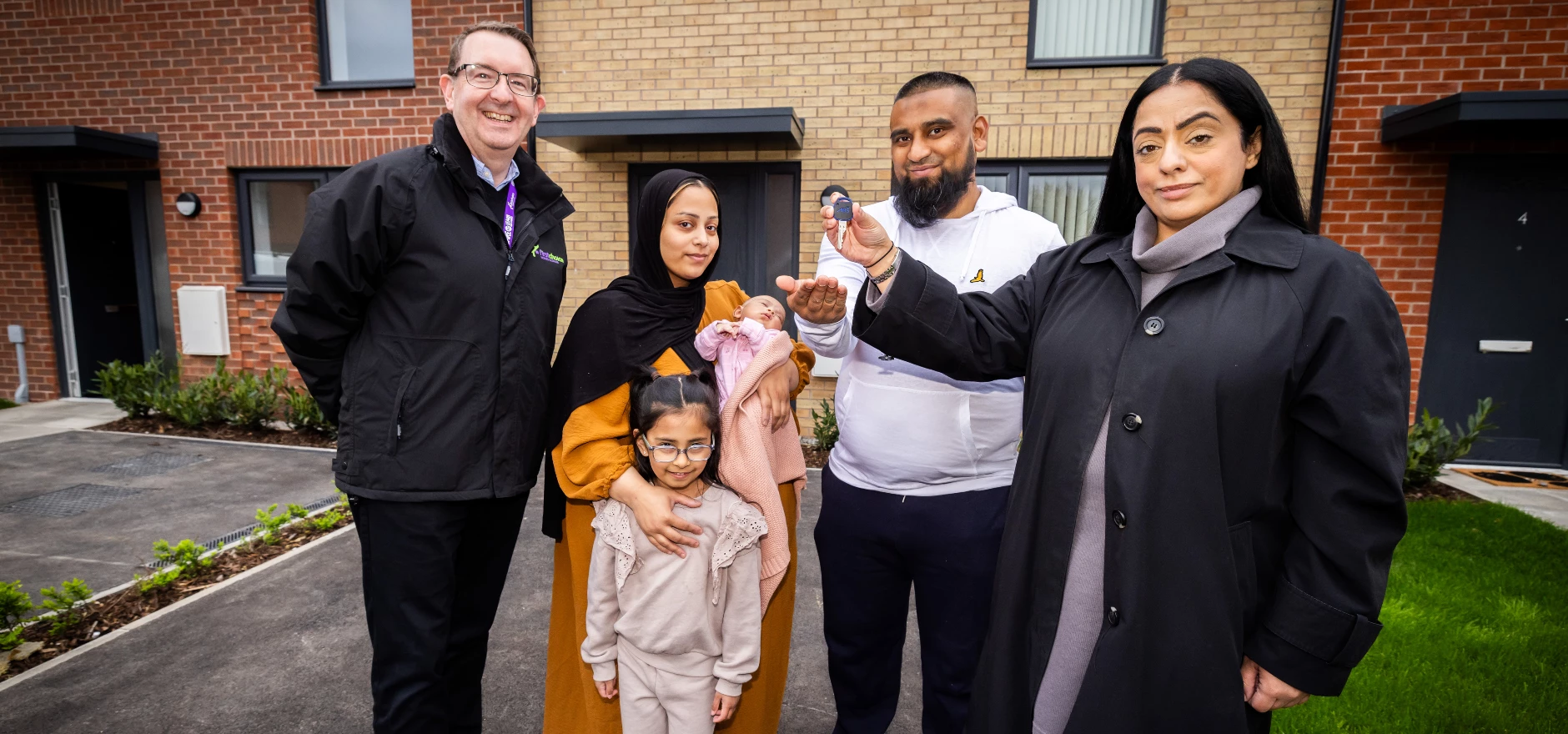 FCHO CEO Mark Gifford with OMB Council Leader Arooj Shah handing keys to Mr Ahmed and his family 2.jpg