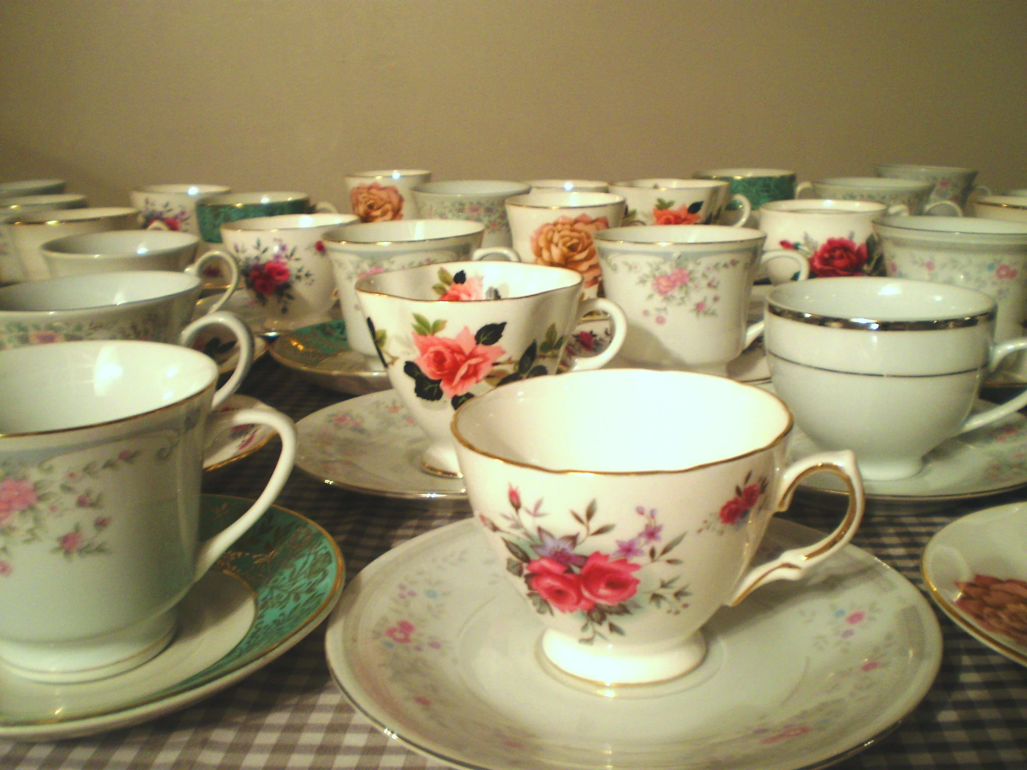 teacups and saucers on gingham cloth