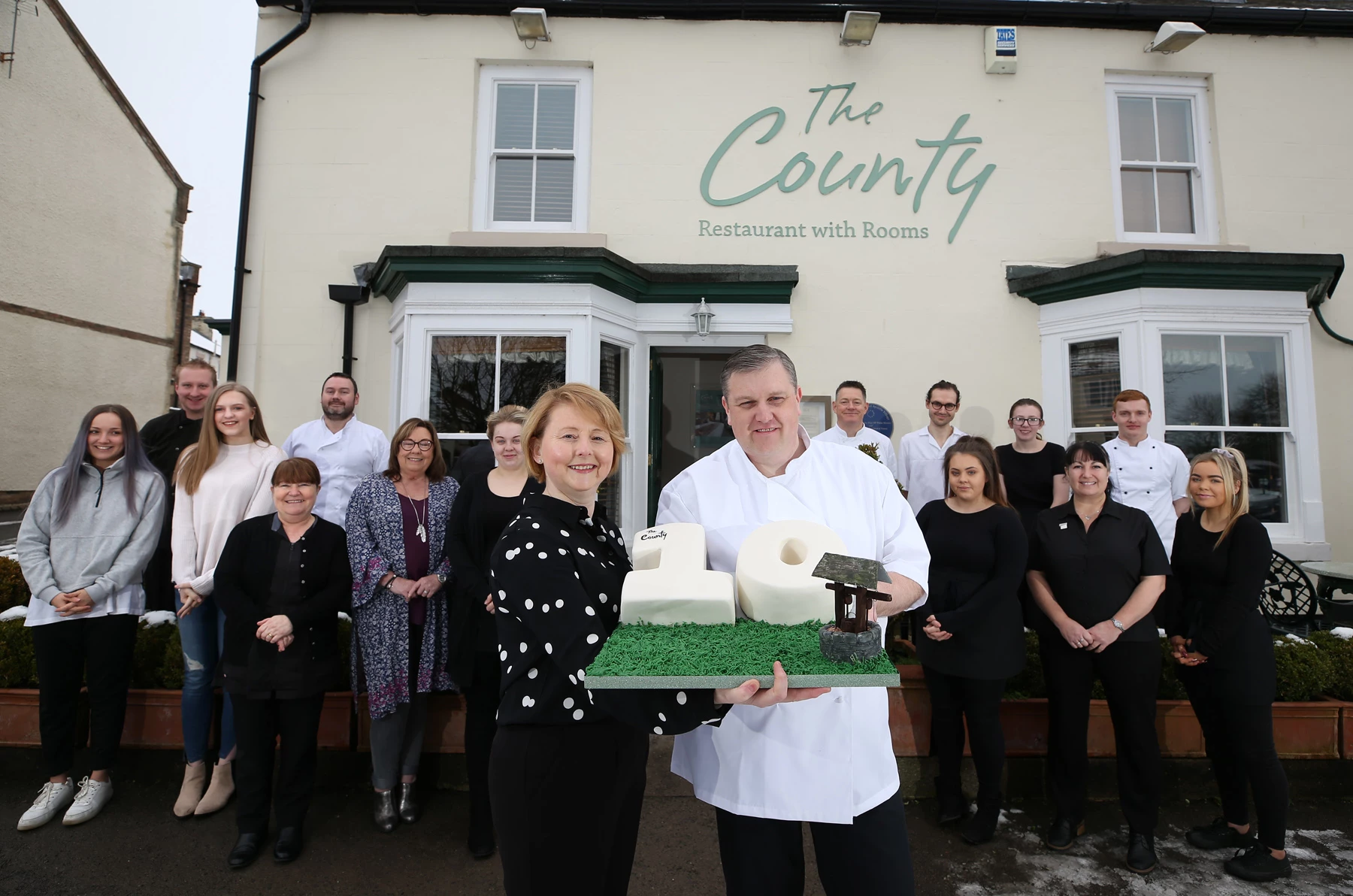 Business Owners Colette Farrell and Stuart Dale holding the birthday cake to celebrate with The County team