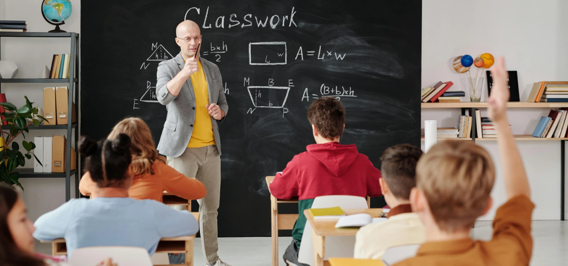 Teacher explaining geometry as students engage in a modern classroom setting.