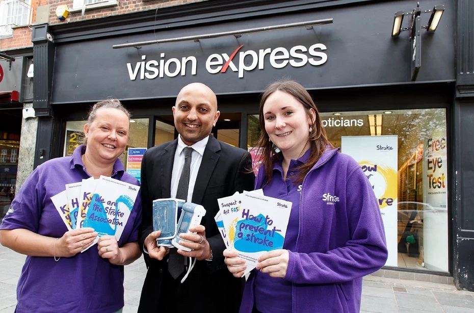Gemma Bamford (L), Information, Advice and Support Coordinator at the Stroke Association and Laura McGregor (R), Communication Support Coordinator at the Stroke Association, with Vision Express St Albans store manager Tony Patel