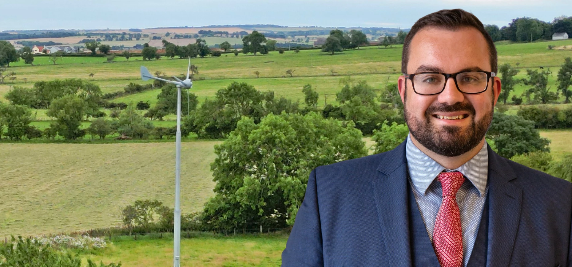Joe Ridgeon, director at Hedley Planning, pictured in front of a wind turbine.