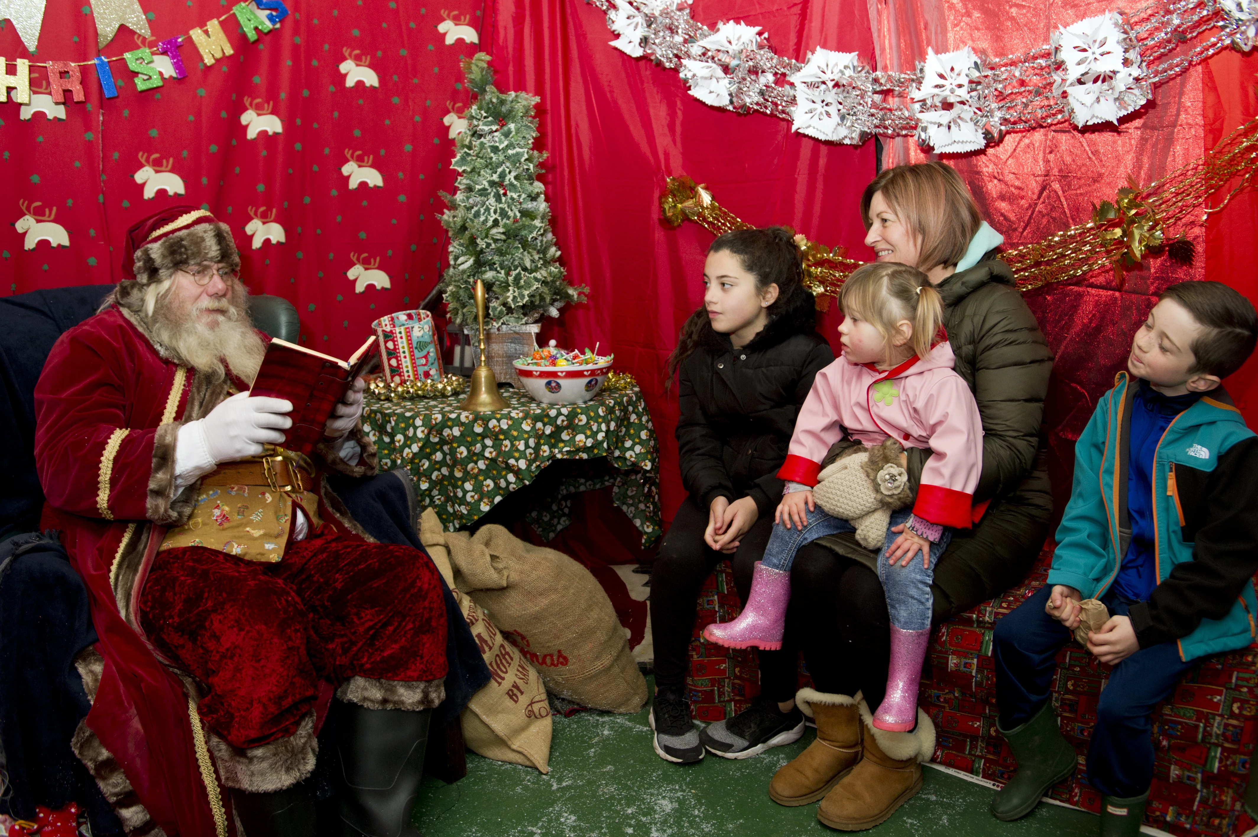 Santa welcomes a family to his grotto