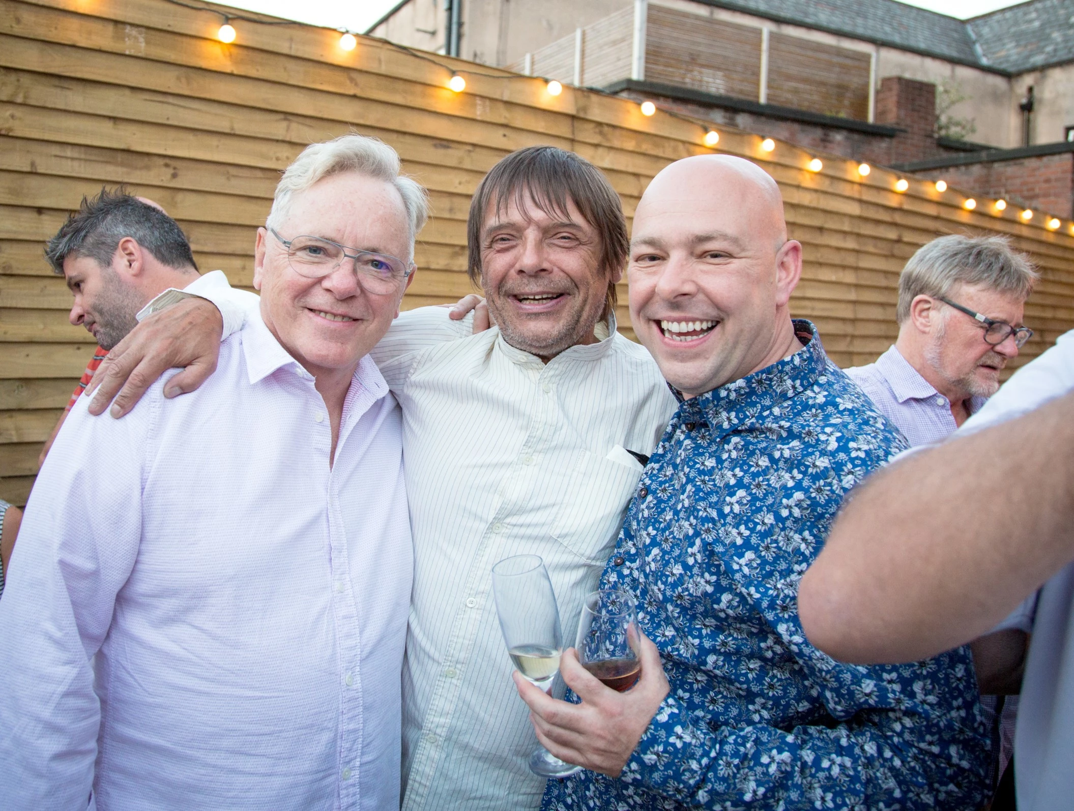 Bernard Sumner, Mani and Cork of the North owner Marc Hough, celebrate the opening of a new outlet in Heaton Moor.