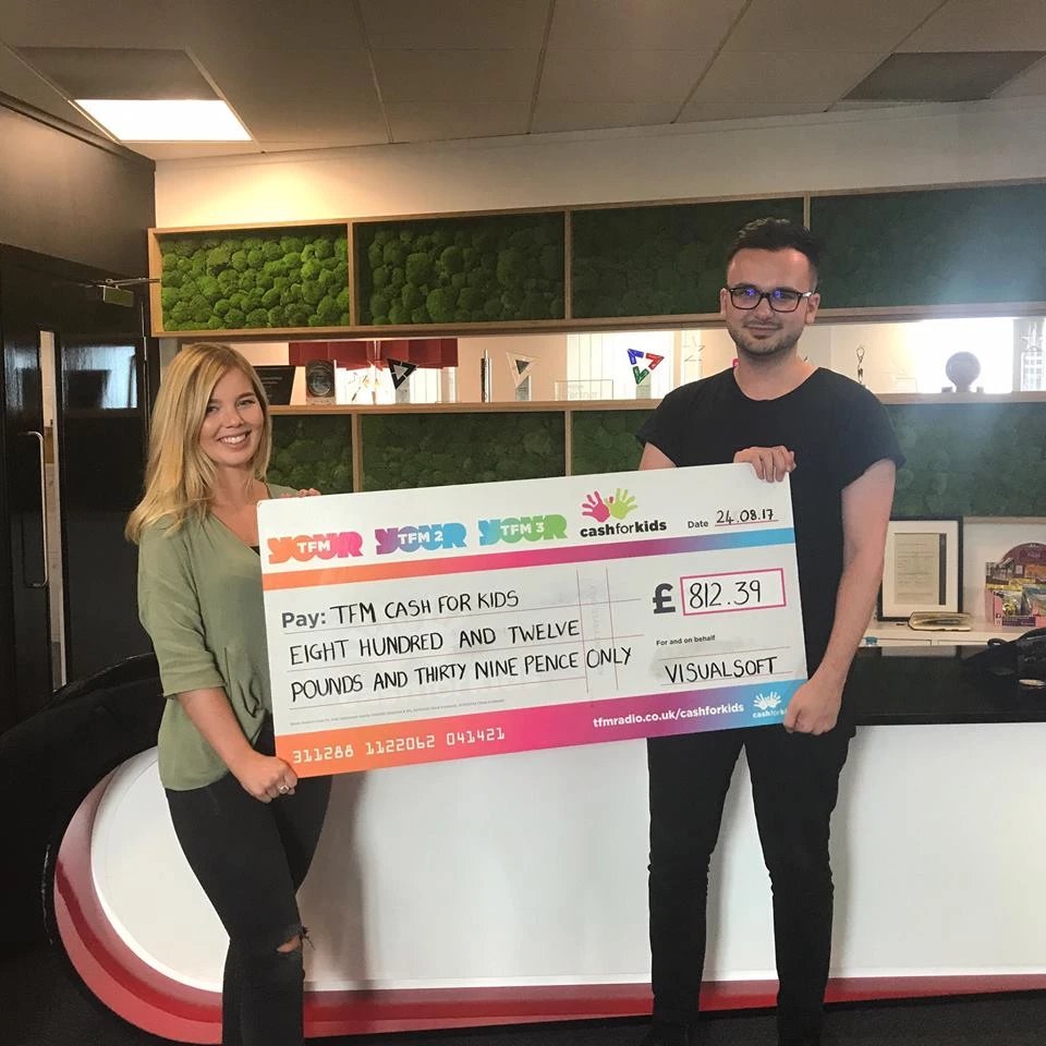 Visualsoft employees holding up the charity cheque