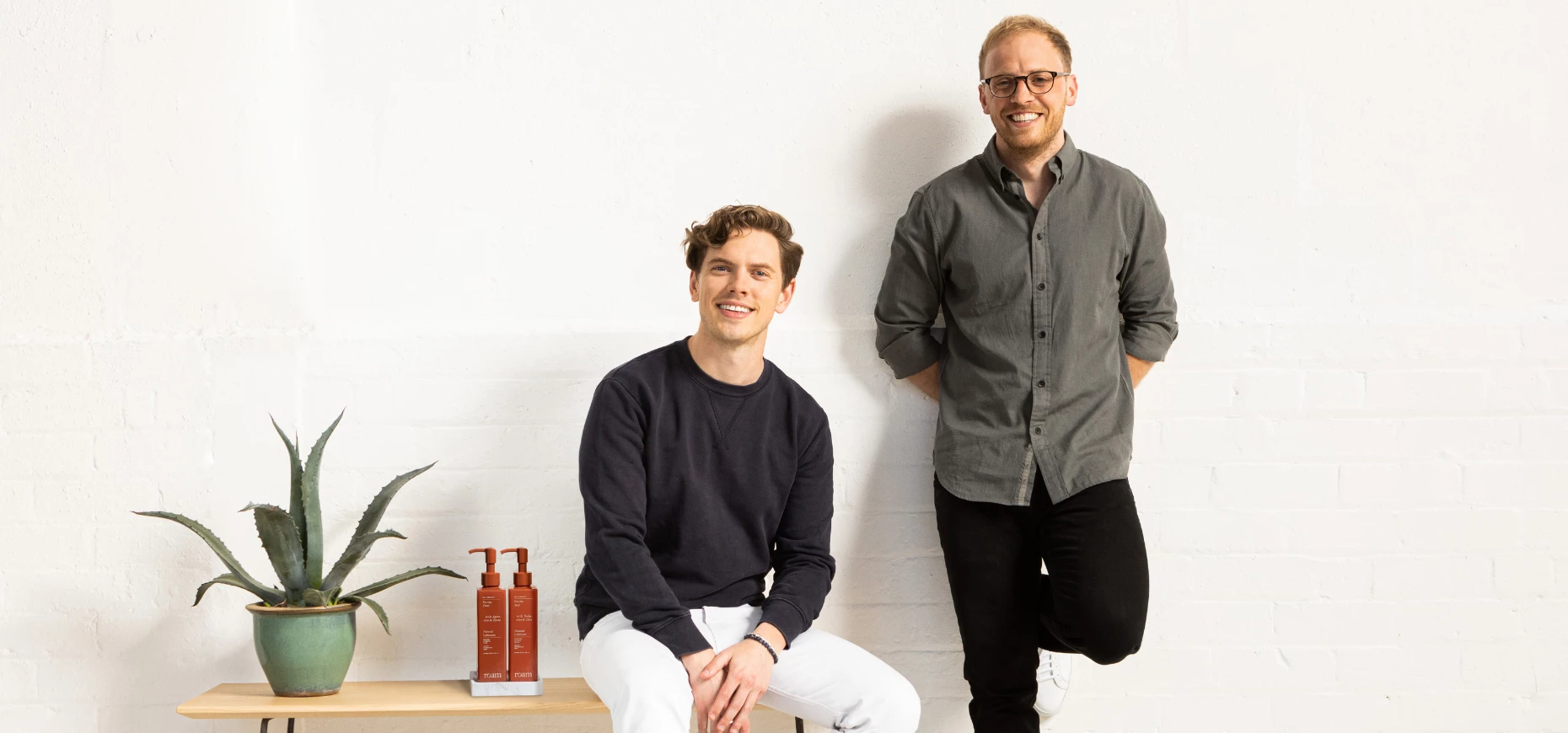 Roam co-founders Alex Griffiths and Ben Taylor sitting next to some of their products.
