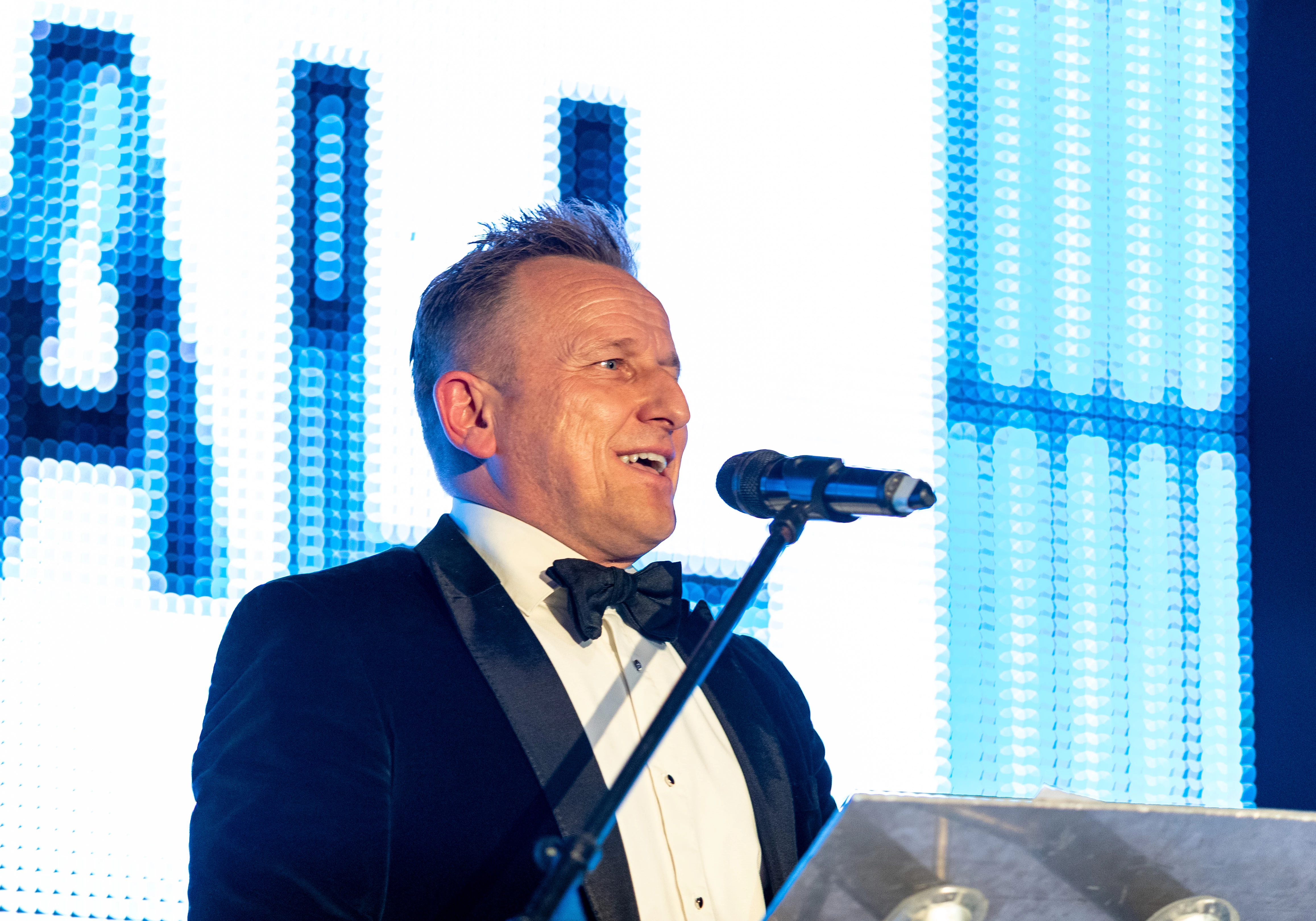 Ian Donaldson speaking on stage at the Football For Change dinner